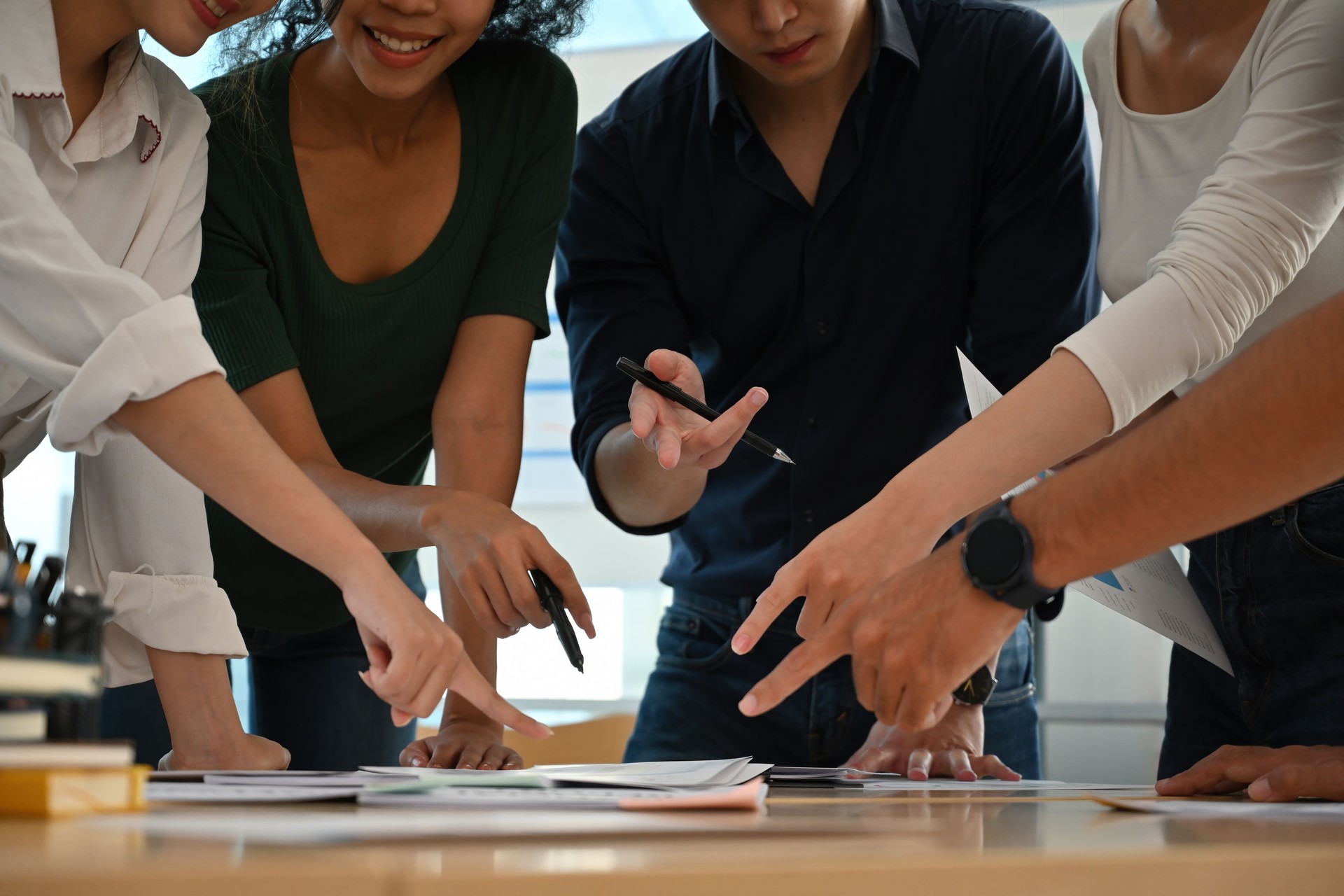 Close-Up of Diverse Team Collaborating and Pointing at Business Documents